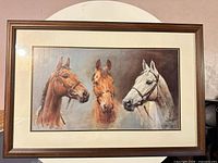 Framed print showing three horse portraits