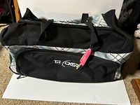 Full view of Tracker rolling duffel bag front with logo and ID tag