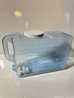 Side view of translucent blue water jug showing handle, lid and spout