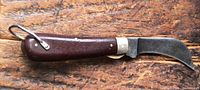 Knife open on wood surface showing full profile, Bakelite handle, steel blade