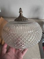 Overall view of pressed glass globe showing ribbed top, diamond-pattern bottom, brass-tone finial