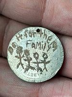 Side A showing text “Do it for the Family” and stick-figure engraving on coin pendant