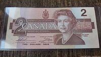 Obverse of 1986 $2 banknote showing Queen Elizabeth II and coat of arms in plastic holder