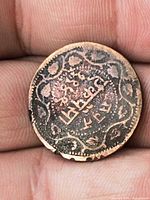 Obverse of copper coin with Arabic inscription and floral border