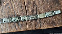 Full view of bracelet laid flat showing all seven animal panels and clasp