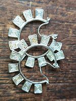 Front view of both sterling silver hoop earrings showing spiral square panels