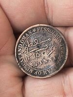 Obverse showing English legend and Arabic centre