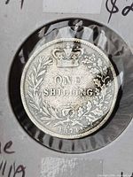 Reverse of 1874 one shilling coin in holder