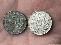 Obverse side of both 1927 and 1935 Canada 5-cent coins in hand