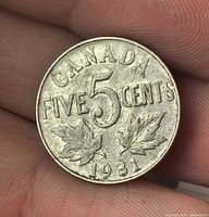 Reverse of 1931 Canada 5 cent coin showing denomination and maple leaves