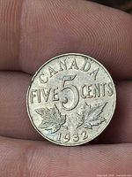 Reverse side of 1932 Canada 5-cent coin showing date and maple leaves