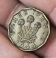 Reverse of 1944 three pence coin showing thrift plant and date