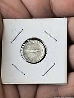 Reverse view: mackerel design and 10 CENTS CANADA 1867-1967 legend on dime in holder