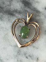 Front view of gold-plated sterling silver heart pendant with green jade stone
