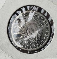 Reverse of 1912 French 50 centimes coin showing olive branch, denomination, Liberté Égalité Fraternité motto, date