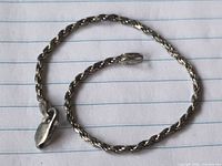 Bracelet laid flat showing rope chain links and clasp