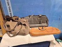 All three handbags: taupe hobo, grey satchel, tan clutch