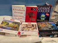 Group shot of three books and three puzzle boxes