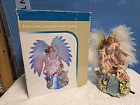 Figurine beside original box displaying product image