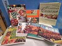 Group shot showing all eight cookbooks arranged upright and overlapping