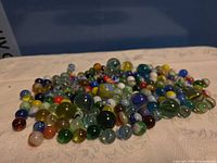 Pile of multicolour glass marbles on cloth surface