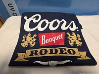 Folded navy t-shirt showing full Coors Banquet Rodeo front graphic