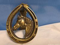 Front view showing horse head within horseshoe frame