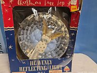 Front of boxed tree topper showing angel and reflector disc