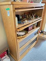 Front view showing oak barrister-style bookcase with four glass drop-front sections, contents inside for scale