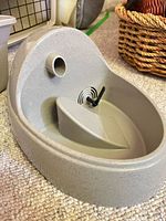 Grey speckled plastic pet water fountain base with spout opening and pump port