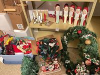 Overview of lot showing ceramic tree, carved Santas, wreath, lights, tote and tray