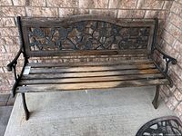 Front view of entire bench showing cast iron frame, decorative back, wood slats