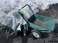 Garden cart and folded canopy with stakes visible