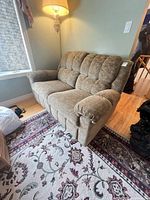 Loveseat front three-quarter view showing upholstery, tufted back, pillow arms