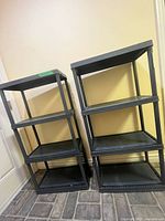 Two black resin shelving units side by side