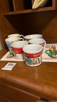 Group of Kellogg's cups, Campbell's mugs, bowl and placemat on wooden surface