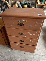 Front view of wooden dresser showing four drawers and hardware