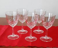 Five Diamant pattern crystal goblets standing on a red cloth