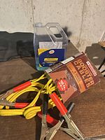 Booster cables beside Turtle Wax car wash jug