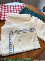 Five folded tablecloths in assorted colors and patterns