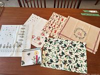 All seven Christmas themed linens laid out on table