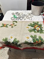 Tablecloth laid out, cookie cutters and planter visible