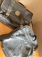 Two black leather satchels on table, showing overall styles