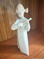 Lladró Girl with Guitar porcelain figurine standing on wooden surface