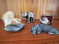 All four small decorative items on wooden surface