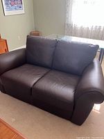 Front view of dark brown faux leather loveseat