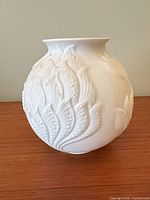 full view of spherical white vase with raised leaf pattern