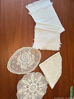 Table runner, four placemats, three crocheted doilies displayed on wooden surface