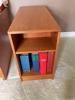 Front view of side table with binders on lower shelf