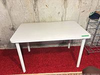 Overall view of white arborite table with four metal legs